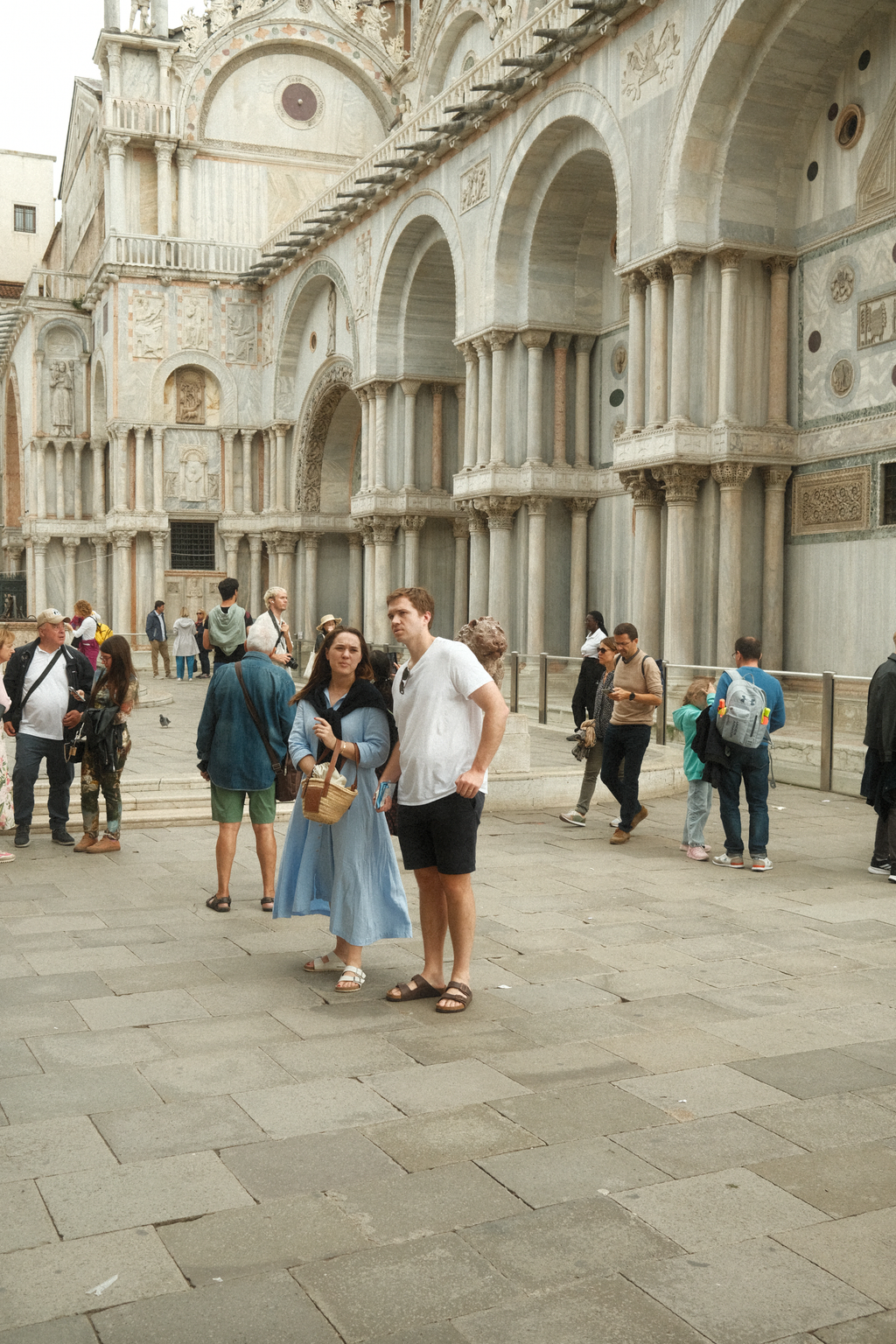 A couple standing in the plaza between the Basilica di San Marco and the clocktower