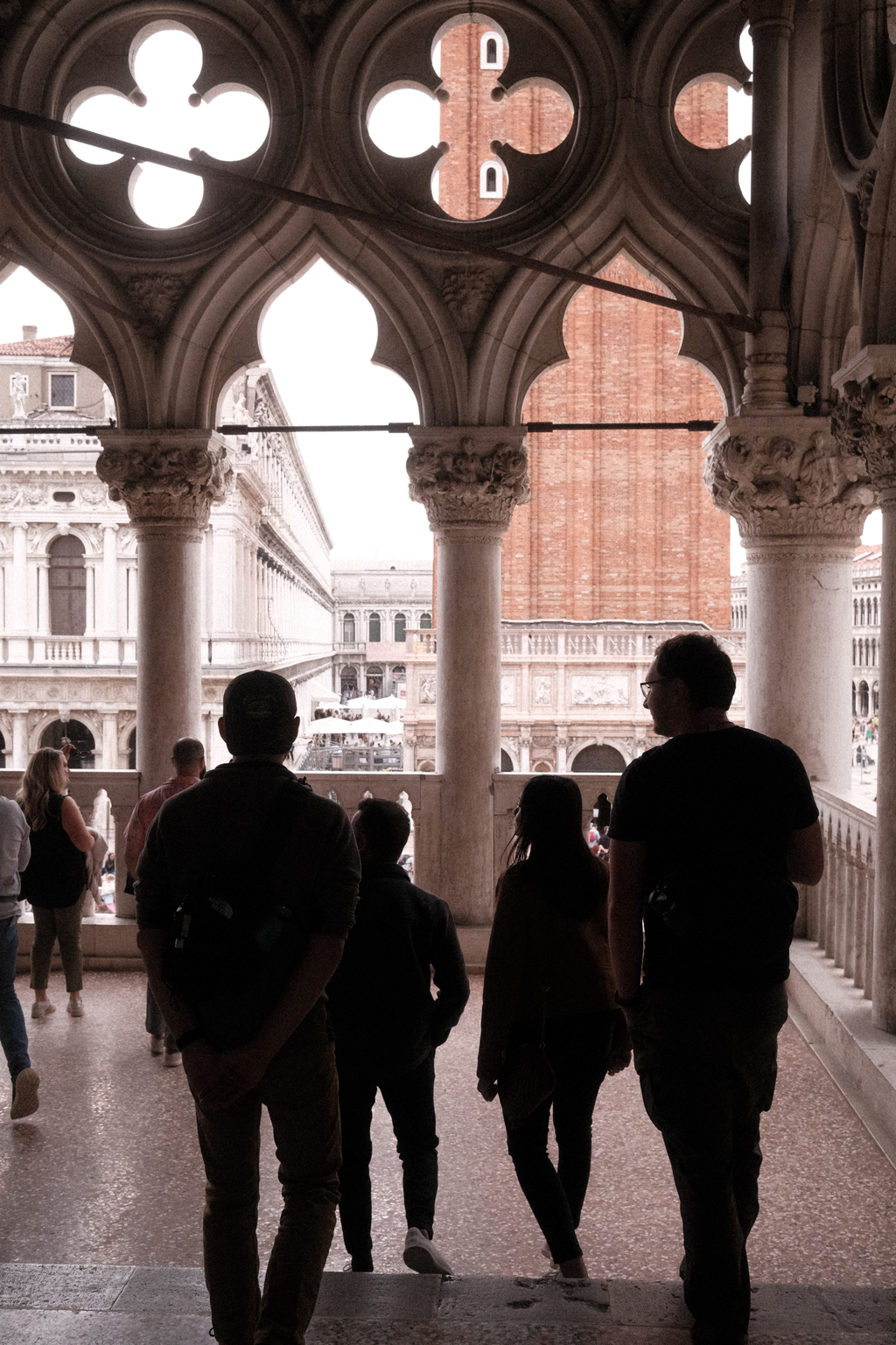 Nick & Tim silhouetted against the marble balcony of the Doge's palace facing the bell tower