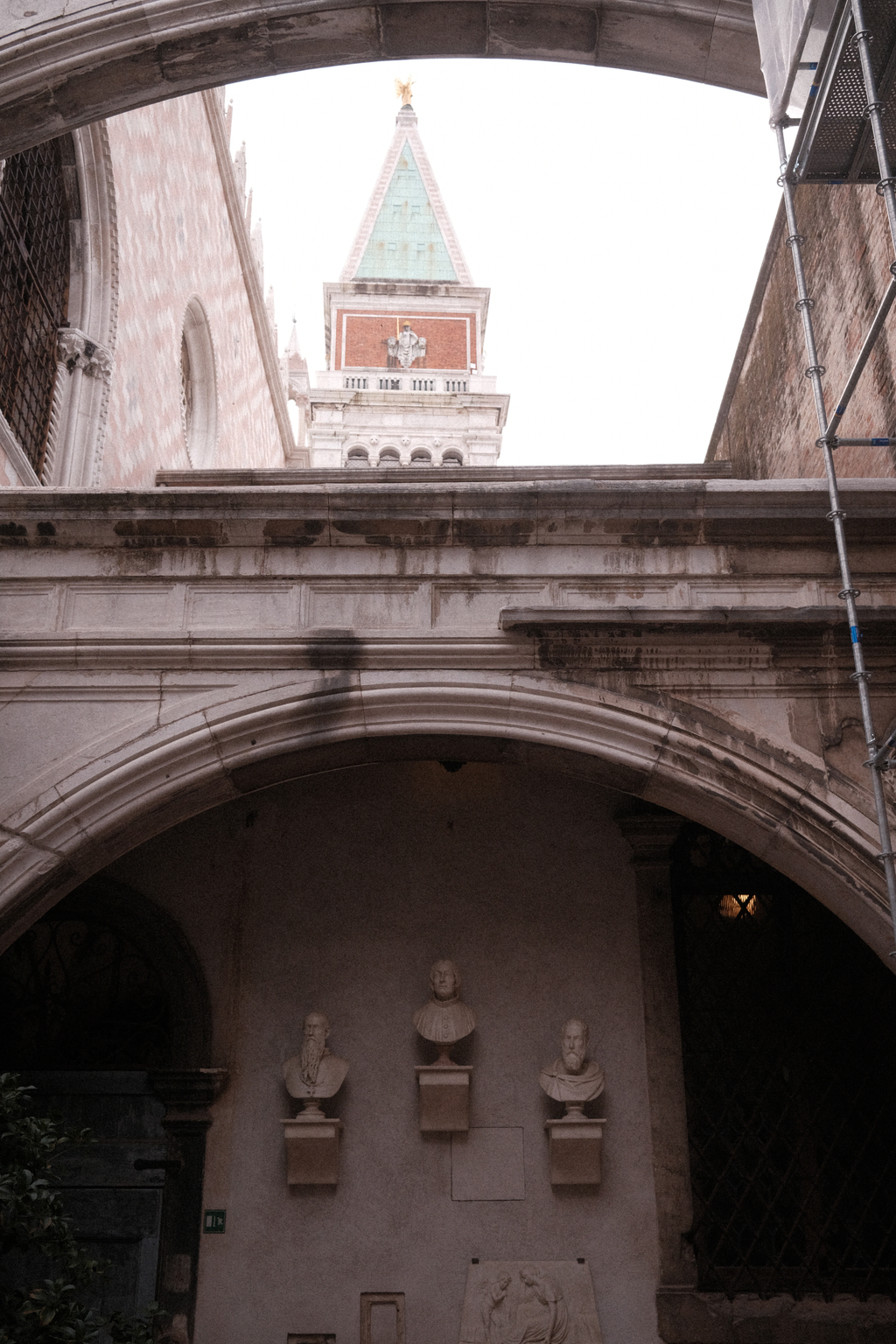 Marble busts of past Doges with the bell tower looming over them