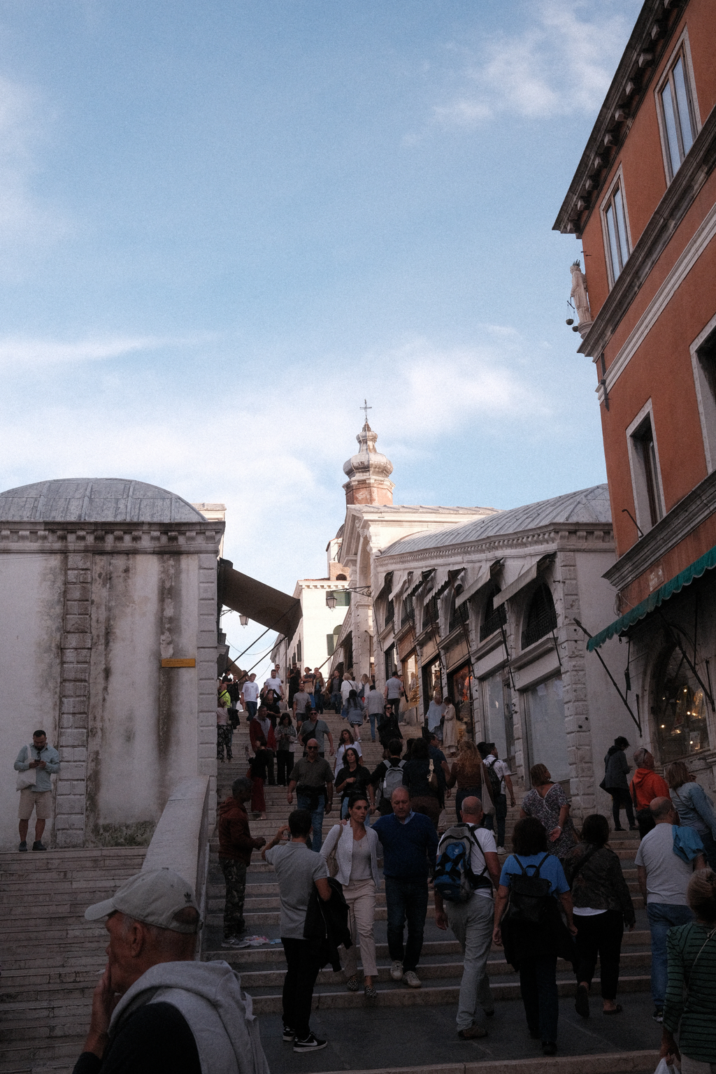 Facing up Rialto Bridge where shop stalls are visible 