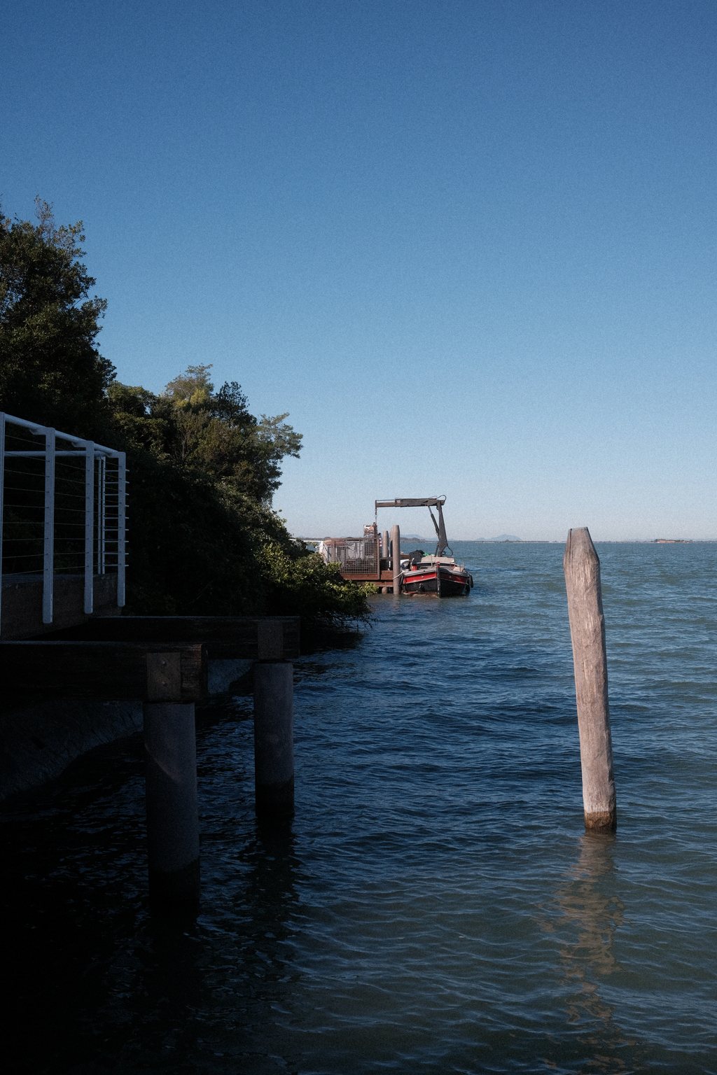 Utility boat fitted with crane for loading items on to/off of docks