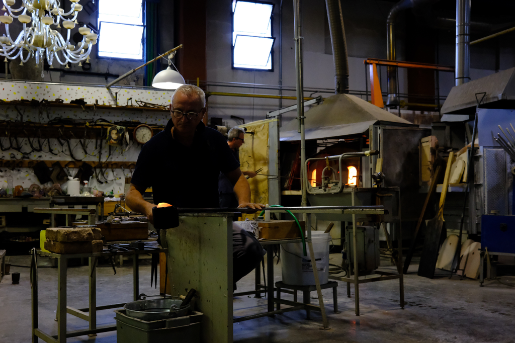 Glass blower forming a bead of molten glass