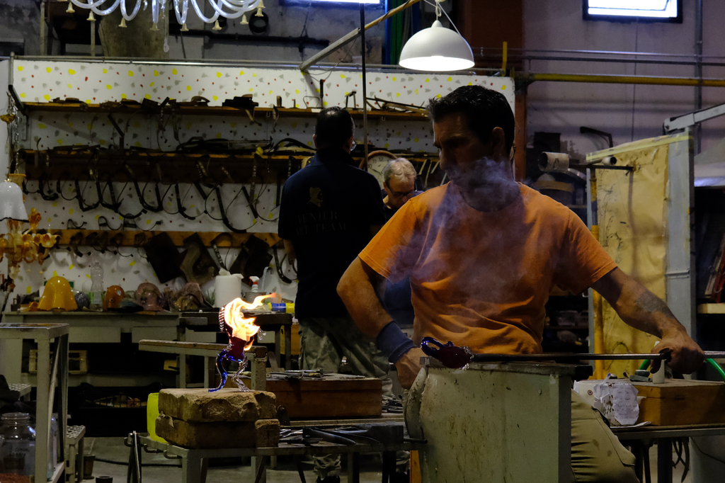 Glass blower watching flash-paper on a fresh glass sculpture