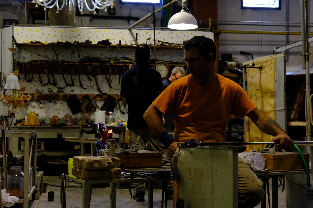 Glass blower watching flash-paper on a fresh glass sculpture