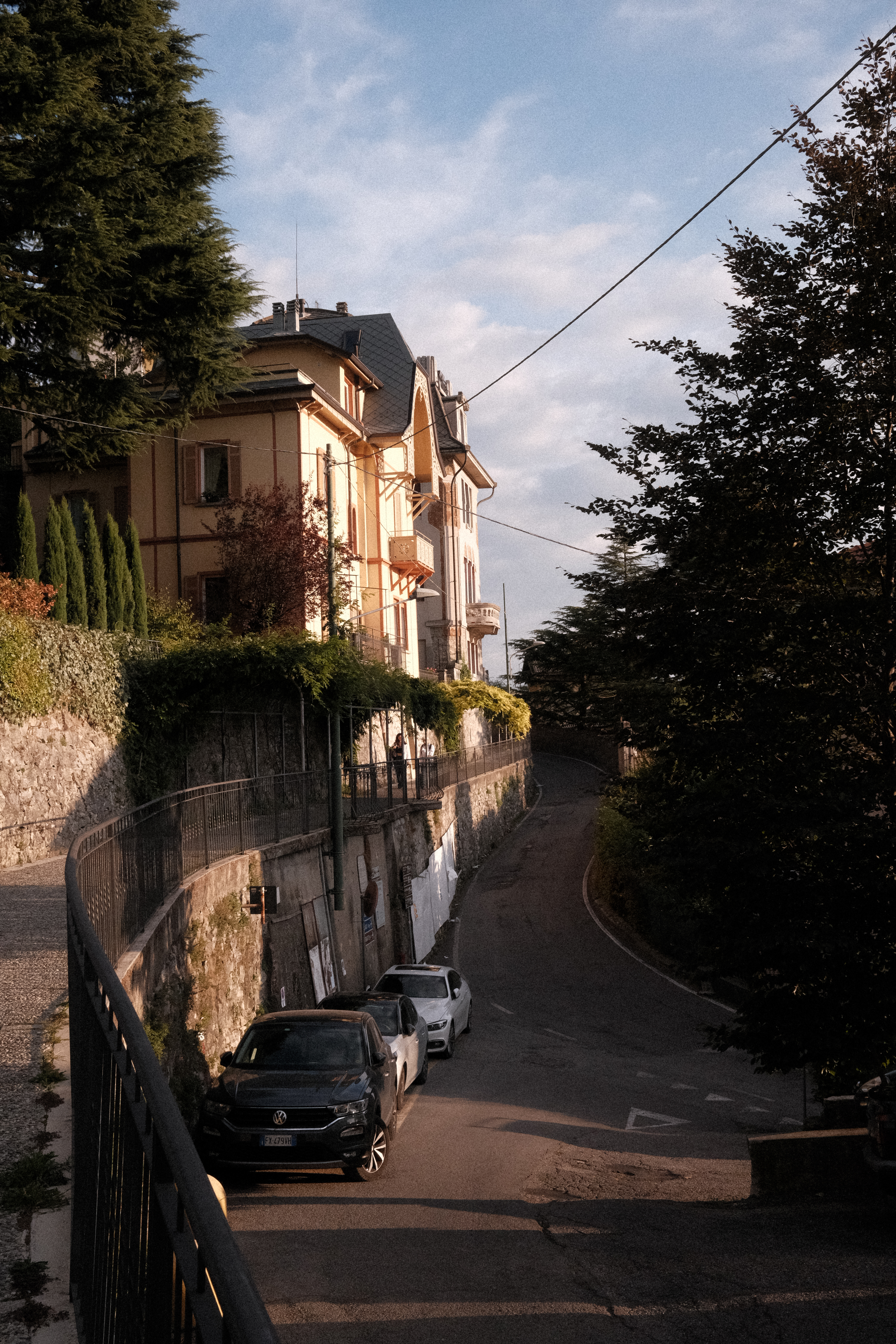 A steep street in Brunate with ivy-clad archways protecting the sidewalk