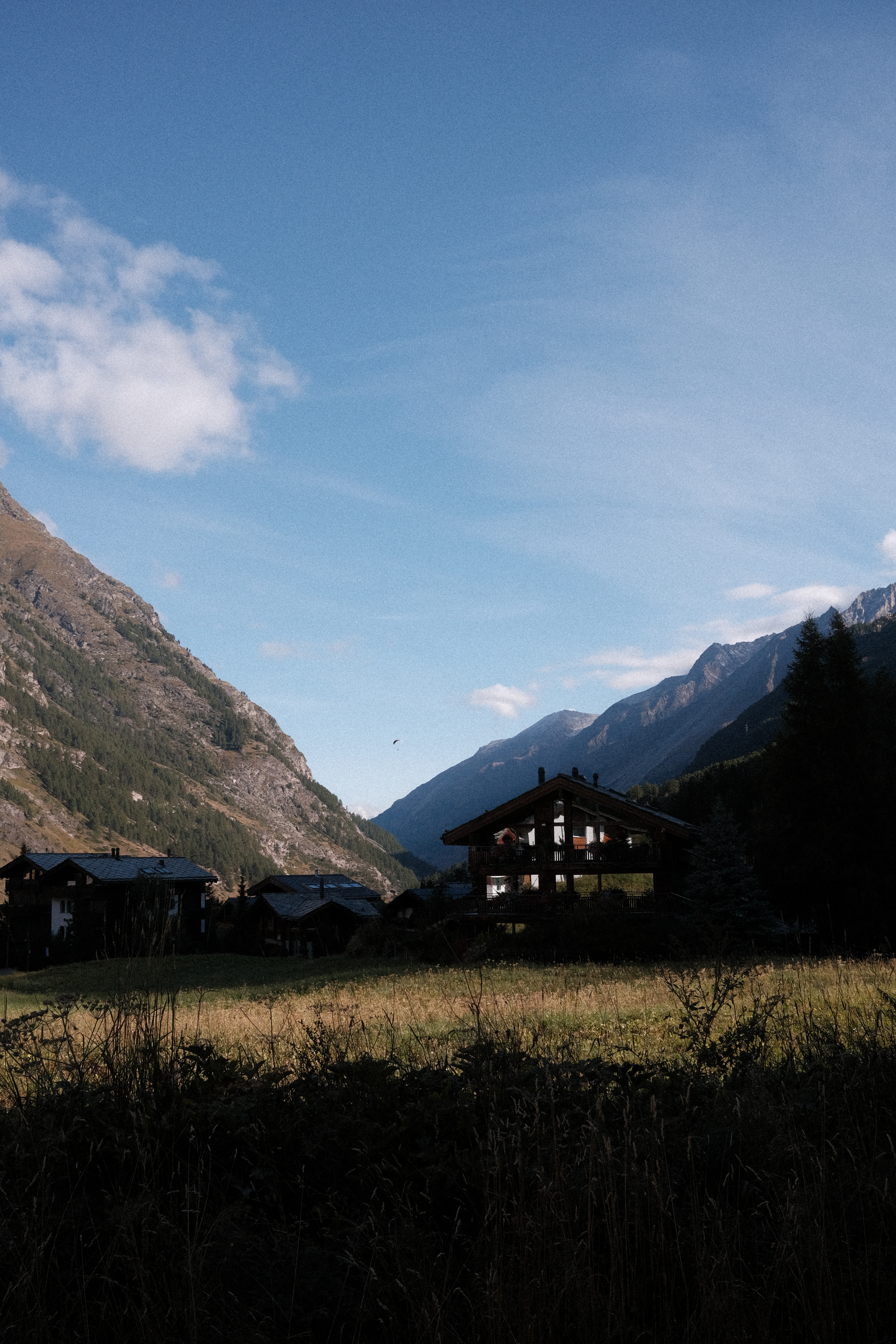 A paraglider in the Zermatt valley in the morning