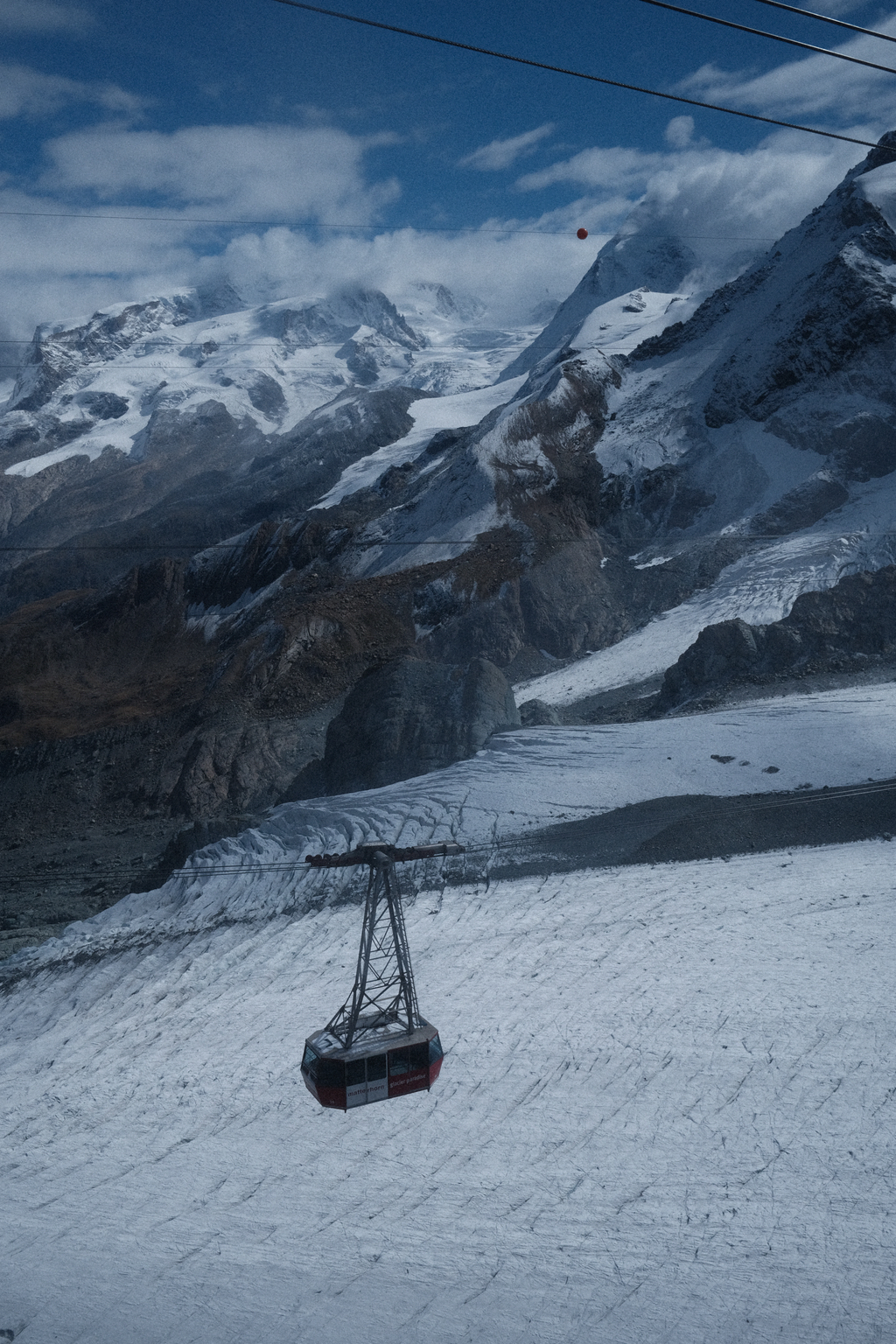 A tram returning from Zermatt Glacier Paradise with Dufourspitze and its accompanying glaciers in the distance