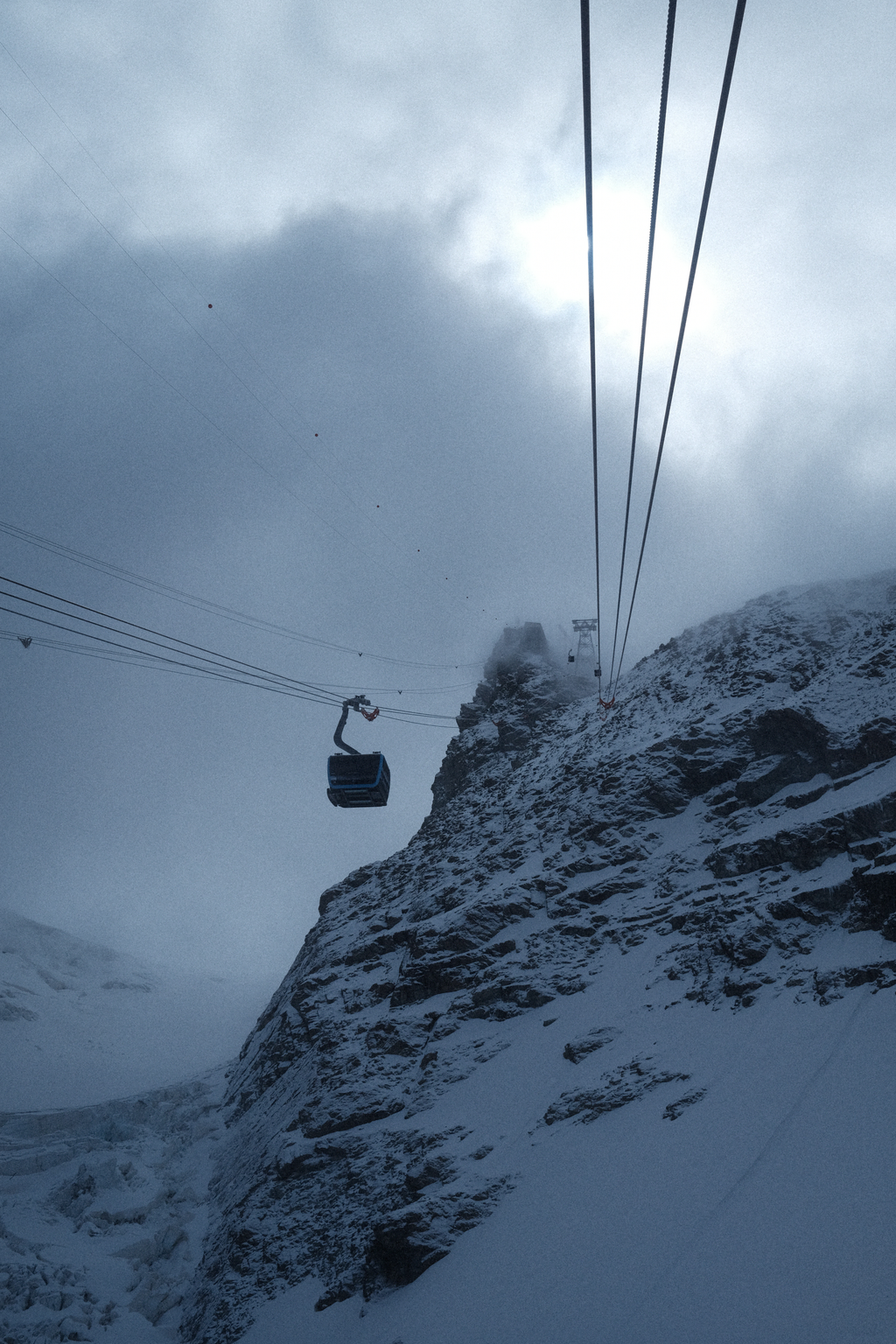 The gondola line climbing into the misty heights of Zermatt Glacier Paradise