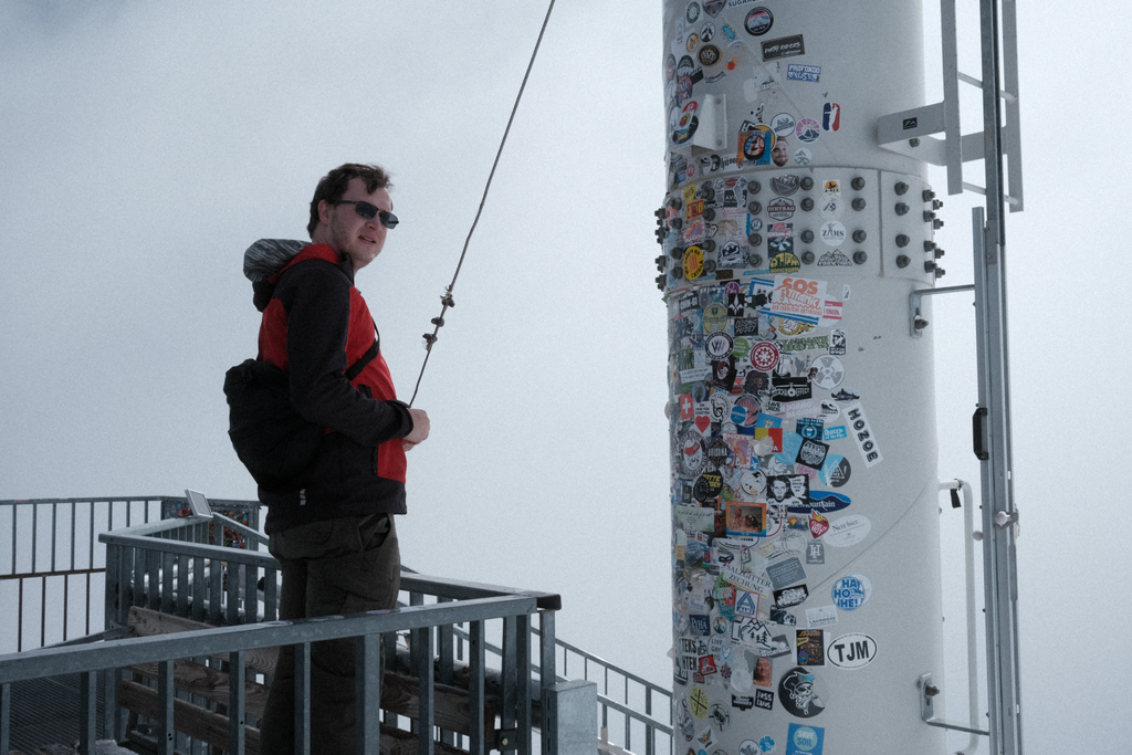 Nick with the pillar of stickers at the observation platform of Zermatt Glacier Paradise