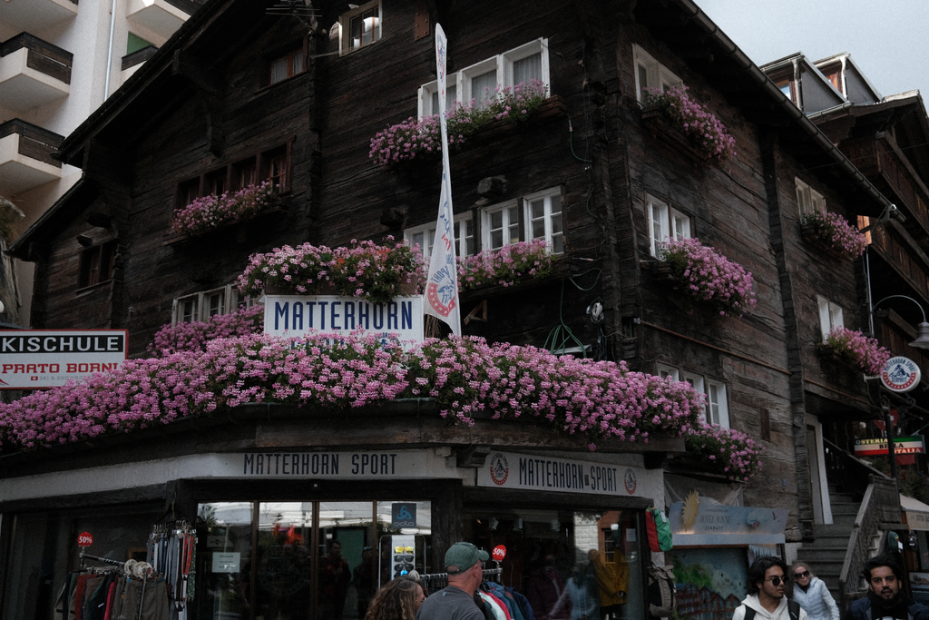 A shop on Bahnhofstrasse adorned with bright pink flowers