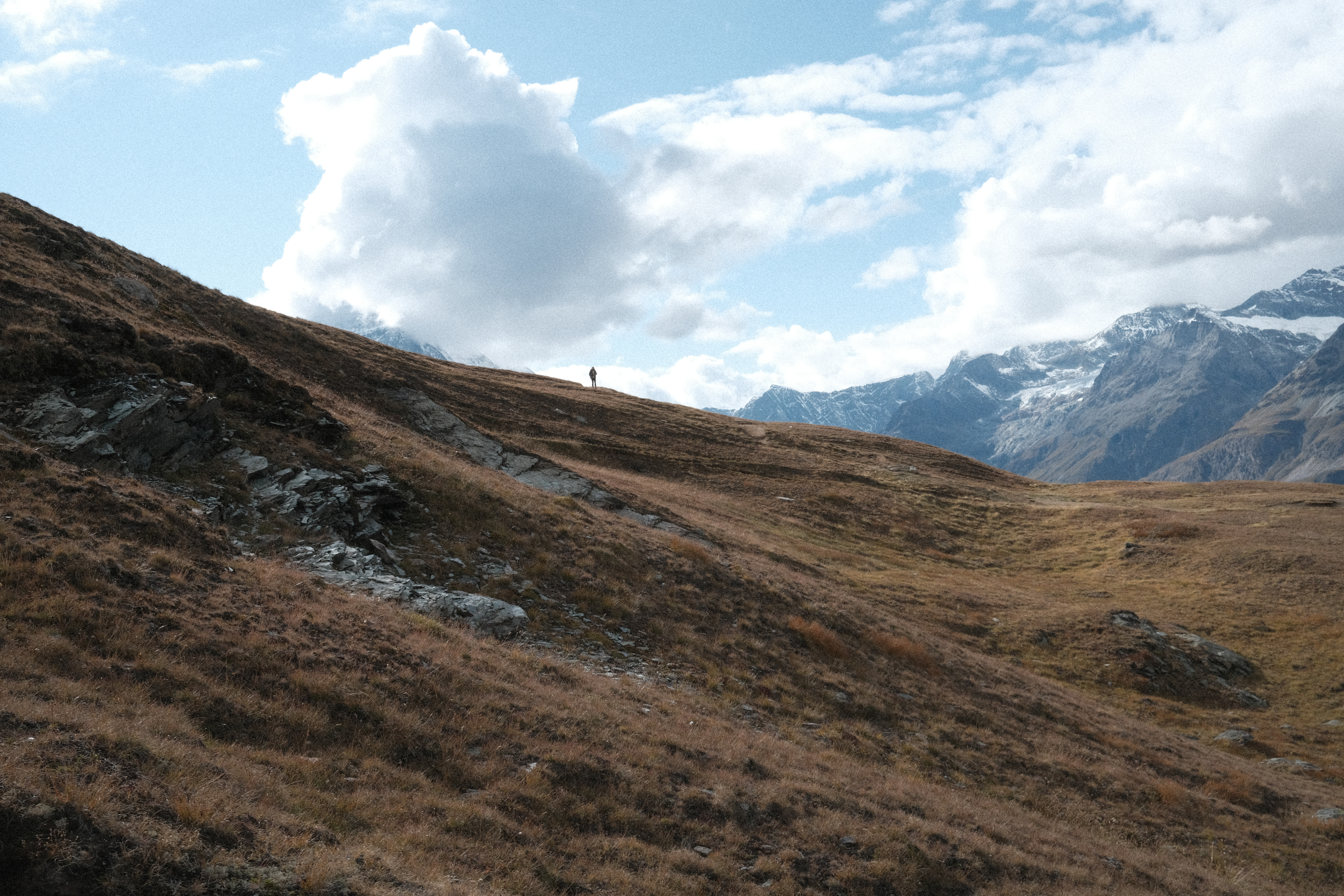 A man hiking down from Gornergrat to Riffelberg across a high-alpine field