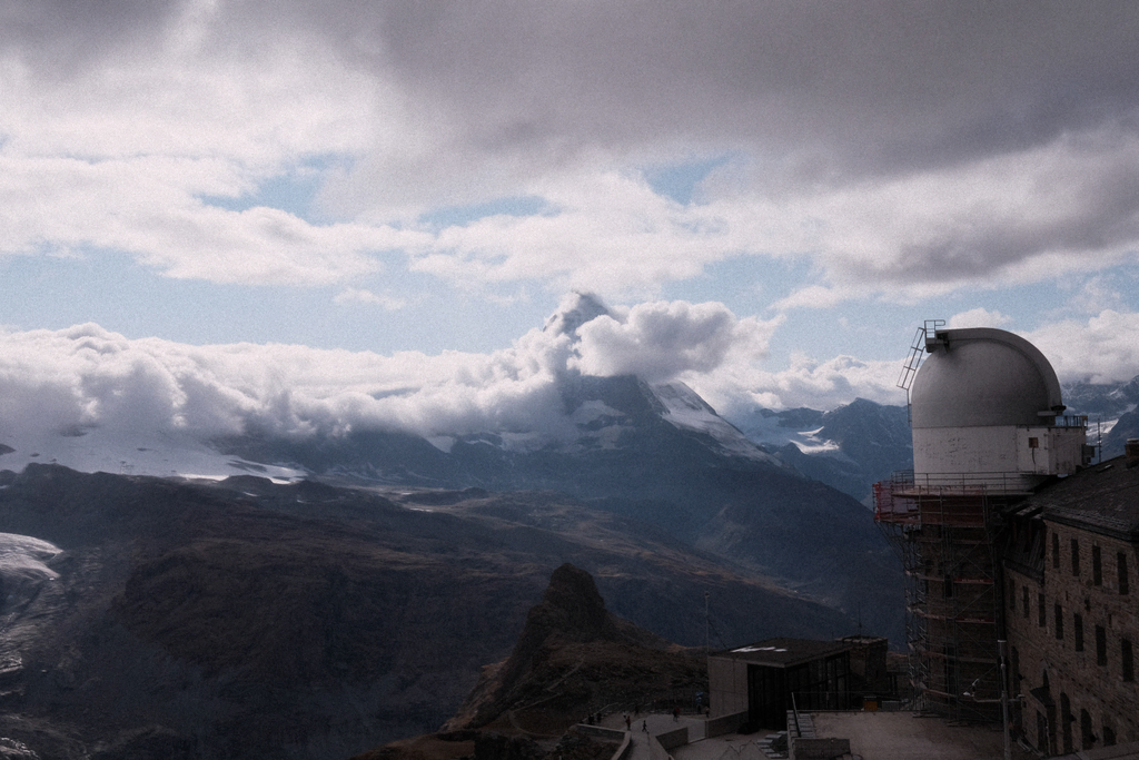 The Matterhorn, partially obscured with clouds, and one of the observatory towers of Gornergrat Observatory