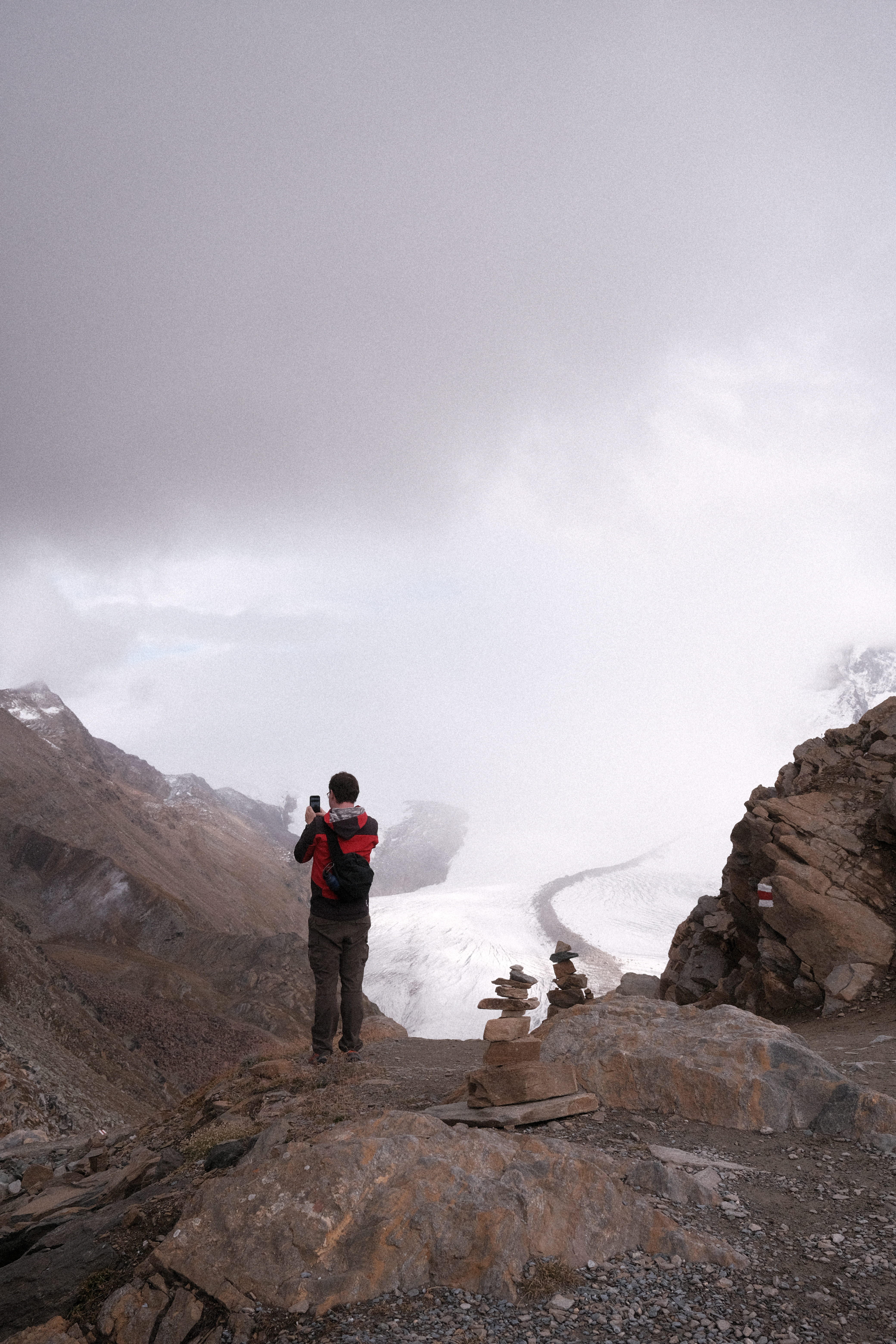 Nick taking a picture of Gornergletscher Glacier with several cairns