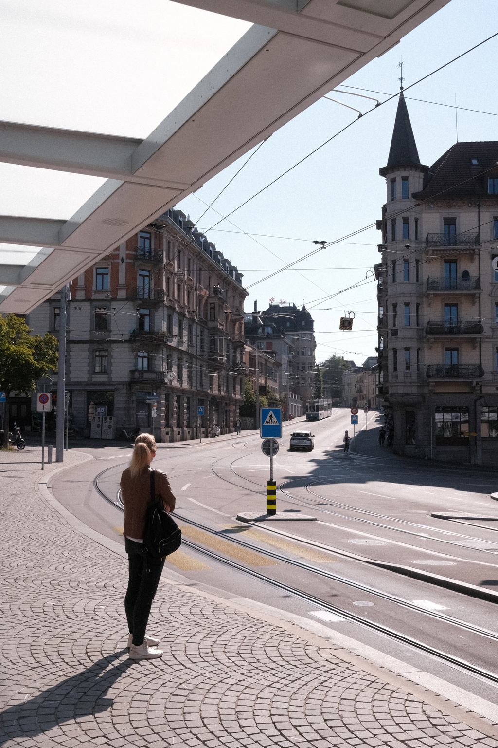 A woman waiting for the tram at the Römerhof tram stop