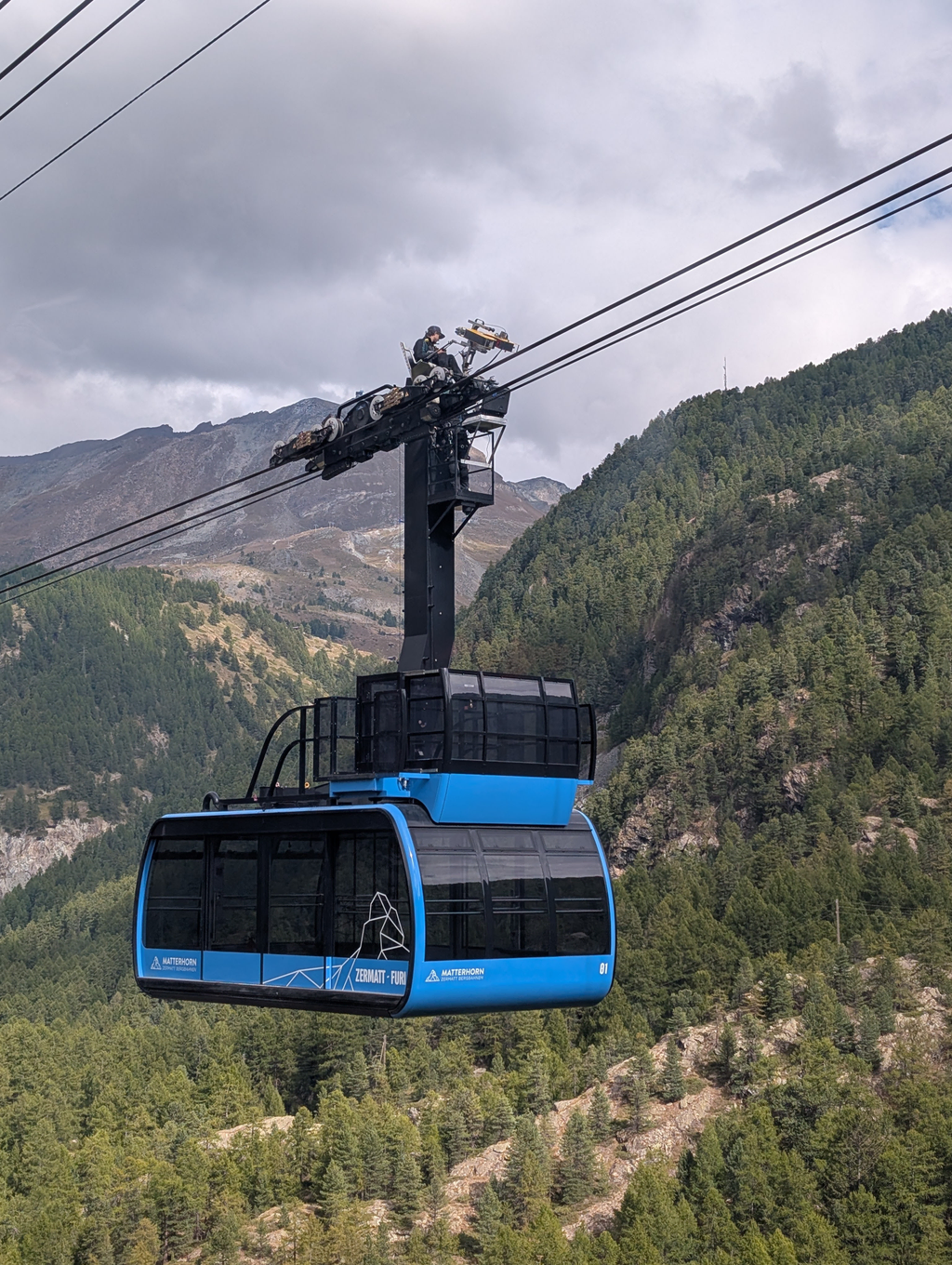 A Zermatt-Furi tram with technician testing the lines